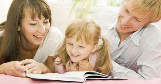 Мама и папа учат дочь читать книгу